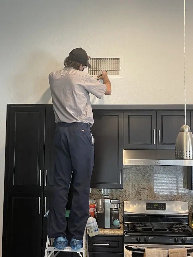 Technician inspecting an air vent during HVAC service in Paradise